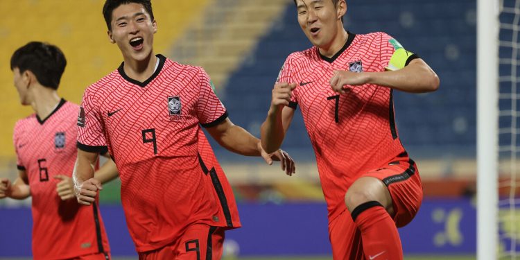 South Korea's foward Son Heung-min (R) celebrates after scoring the second goal during the 2022 Qatar World Cup Asian Qualifiers football match between Iraq and South Korea, at the Thani Bin Jassim Stadium in the Qatari capital Doha, on November 16, 2021. (Photo by KARIM JAAFAR / AFP)