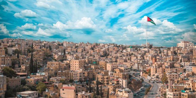 A scenic shot of the city of Amman with the Jordan flag in Jordan